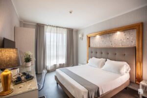 A modern hotel room with a double bed and a desk.